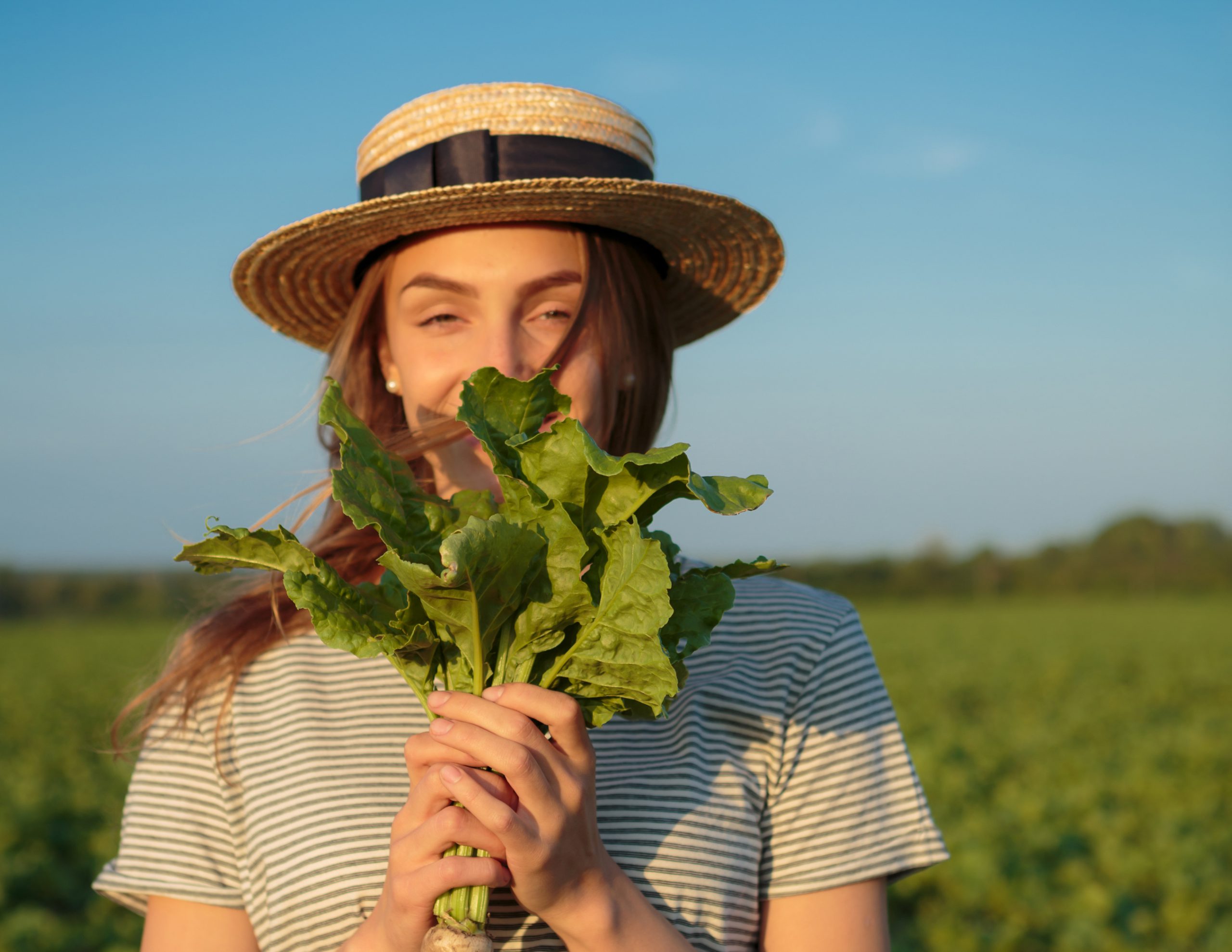 Girl farmer holding sugar beet in hands