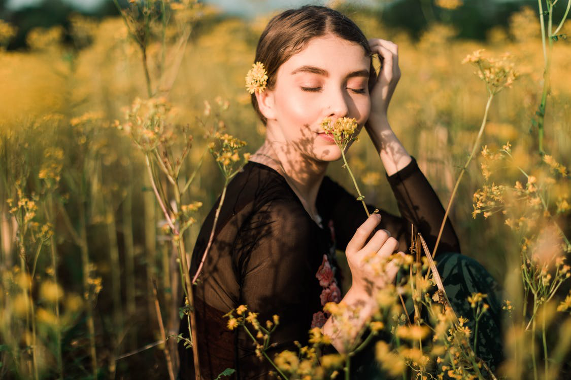 Young woman smells a flower