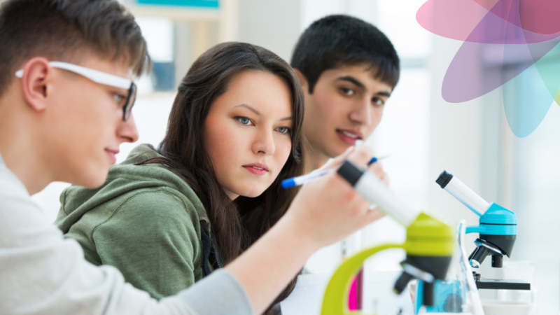 Two young boys and a young girl document their experiments in a laboratory.