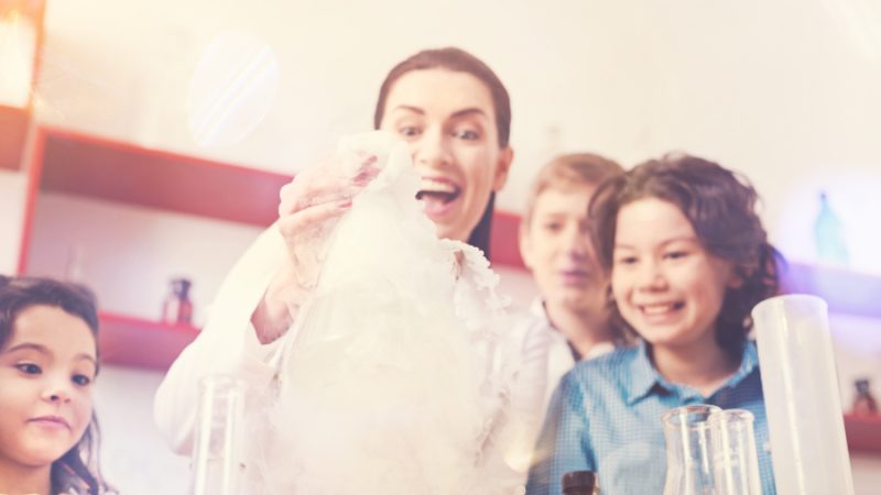 woman expressing positivity while doing experiment with children