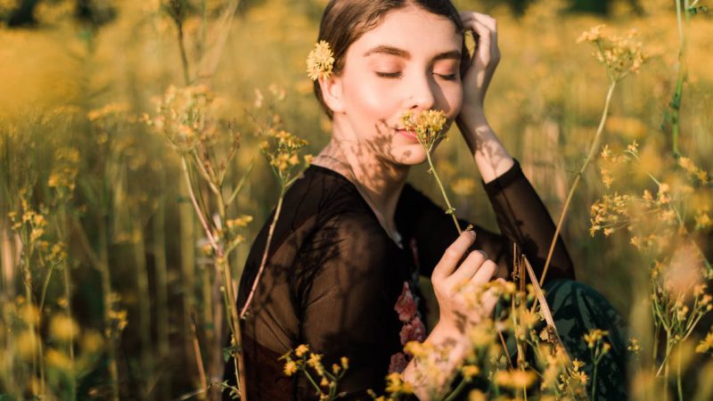 Young woman smells a flower