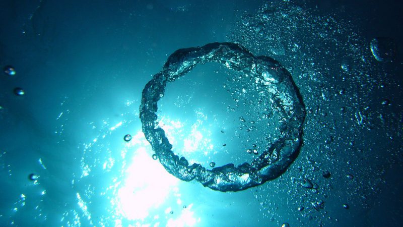 the picture shows several air bubbles and a ring of air under water