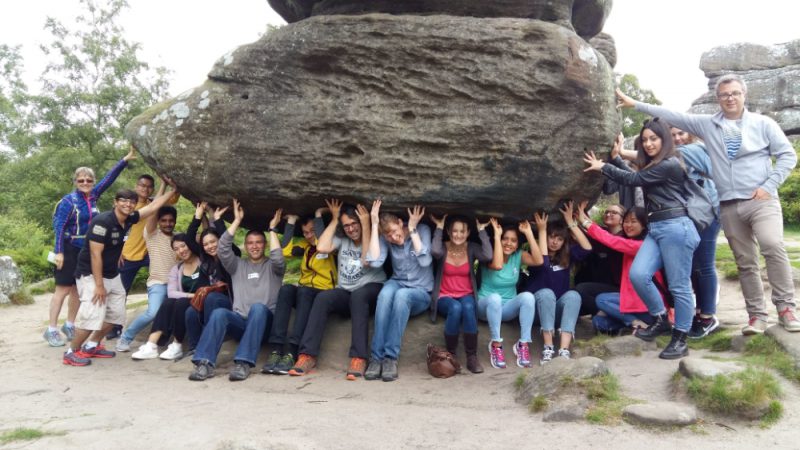 Das Foto zeigt das junge synBIOcarb-Team unter einem großen Felsen.