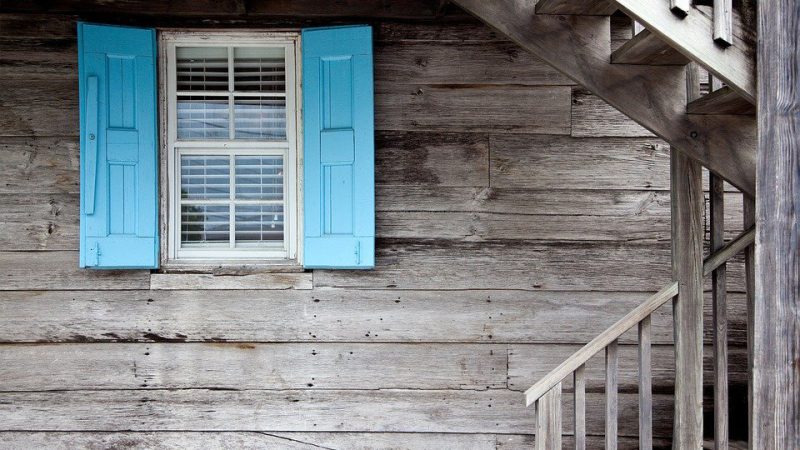 Exterior wall of a wooden hut. The wooden boards are weathered.